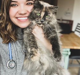 Veterinary client specialist holding a cat (Meghan Hoel)